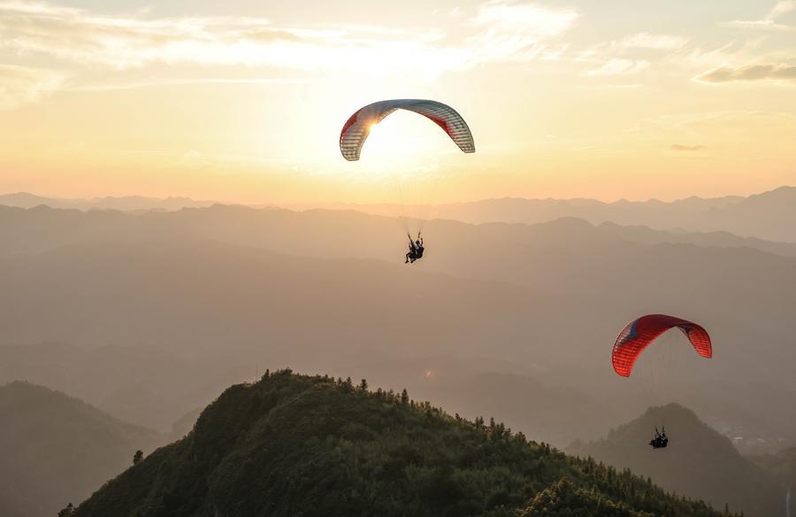 Foto dron bertarikh 30 Julai 2026 ini menunjukkan pelancong meluncur layar bersama peluncur profesional di sebuah pangkalan di pekan Jiuzhou, kaunti Huangping, provinsi Guizhou, barat daya China. (Xinhua/Yang Wenbin)