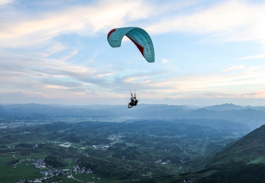 Foto dron bertarikh 30 Julai 2026 ini menunjukkan pelancong meluncur layar bersama peluncur profesional di sebuah pangkalan di pekan Jiuzhou, kaunti Huangping, provinsi Guizhou, barat daya China. (Xinhua/Yang Wenbin)