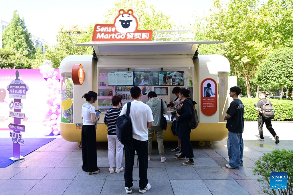 Orang membeli barang di sebuah kedai robot pintar terkandung di Jalan Leijie, Hefei, provinsi Anhui, timur China, 26 Ogos 2026. (Xinhua/Zhou Mu)