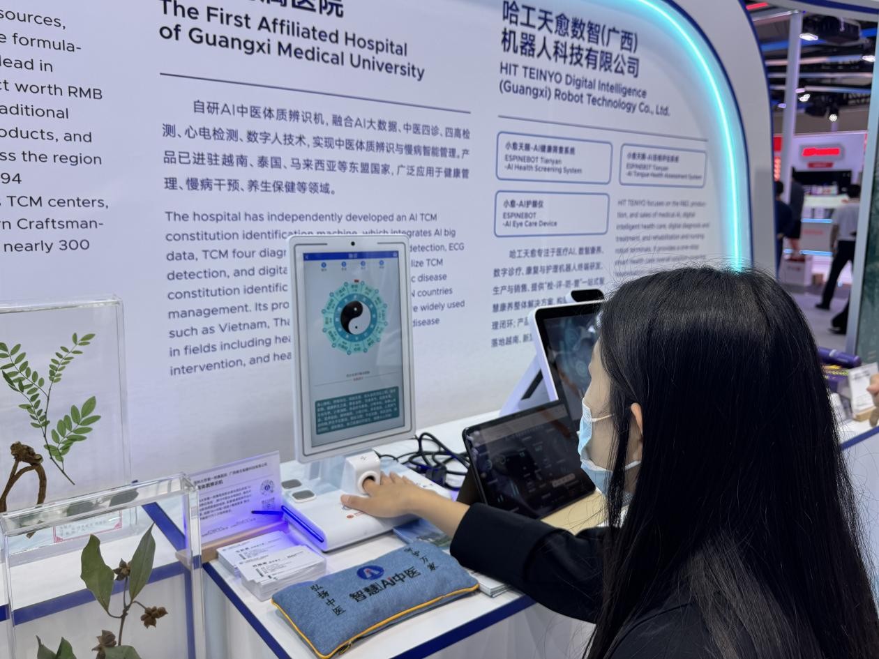 Pelawat mencuba alat jagaan kesihatan Perubatan Tradisional Cina (TCM) berkuasa AI. (People’s Daily Online/Xie Ying)