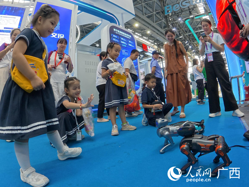 Kanak-kanak berinteraksi dengan anjing robot. Foto oleh Lei Qijun, People's Daily Online