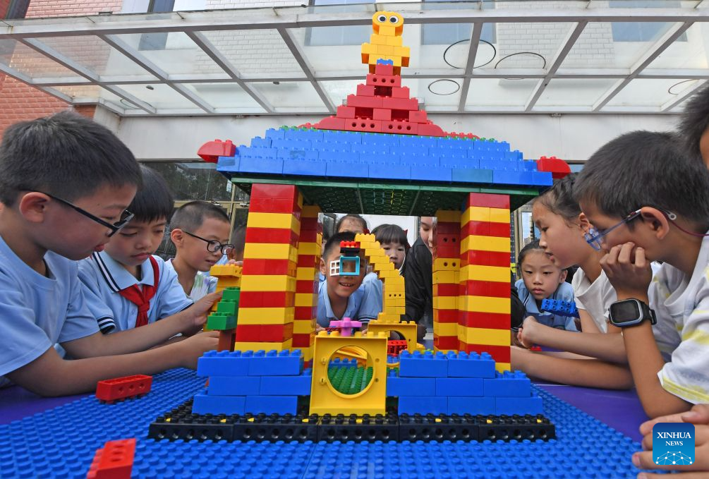 Kanak-kanak membuat model Guang Han Gong, istana yang menjadi kediaman Chang’e dan haiwan kesayangannya Yutu dalam mitos China menggunakan blok mainan, di sebuah sekolah rendah di Quanzhou, provinsi Fujian, tenggara China, 23 September 2026. (Lin Hongqin/Xinhua)
