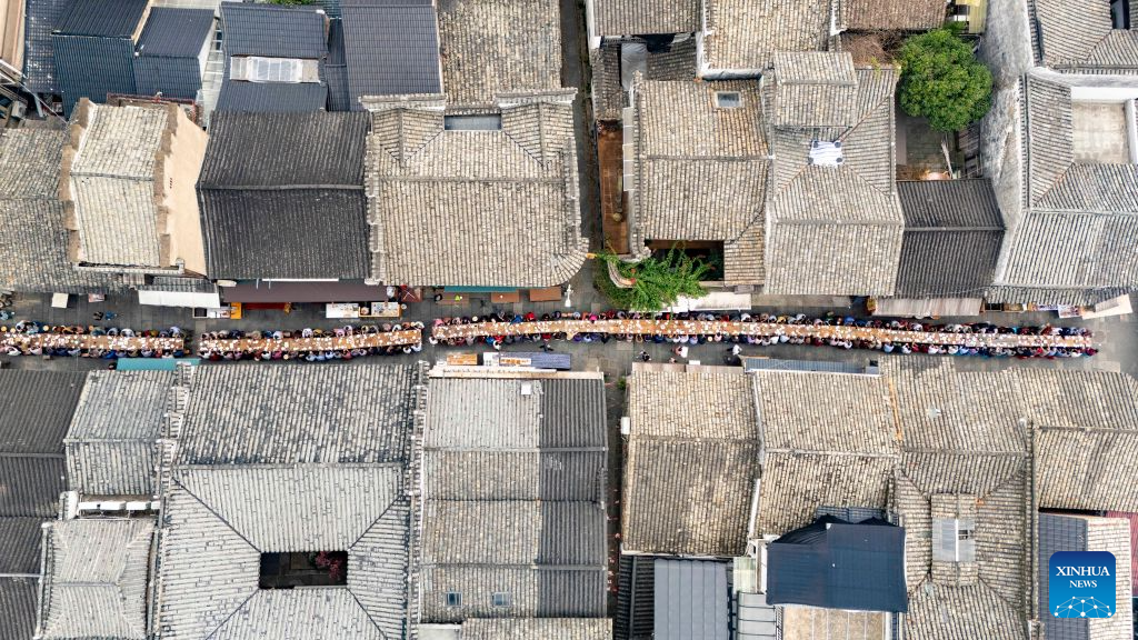 Foto dron yang diambil pada 15 Oktober 2026 ini menunjukkan pemandangan satu jamuan meja panjang bagi meraikan warga emas di Yanggang, Lanxi, provinsi Zhejiang, timur China. (Foto oleh Hu Xiaofei/Xinhua)