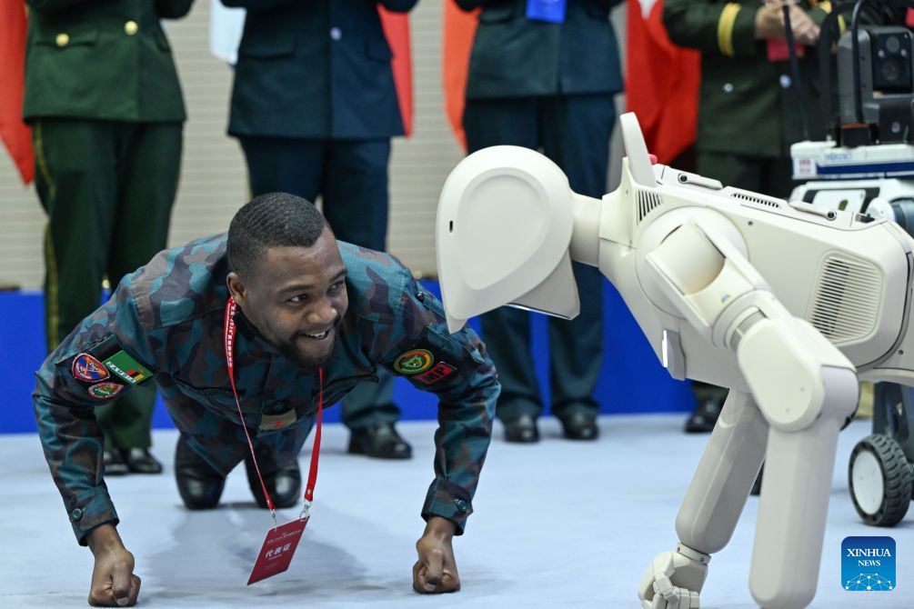 Seorang peserta berinteraksi dengan sebuah robot pada Forum Antikeganasan Antarabangsa Great Wall-2026 di Beijing, ibu negara China, 14 Oktober 2026. (Foto oleh Yue Chang/Xinhua)