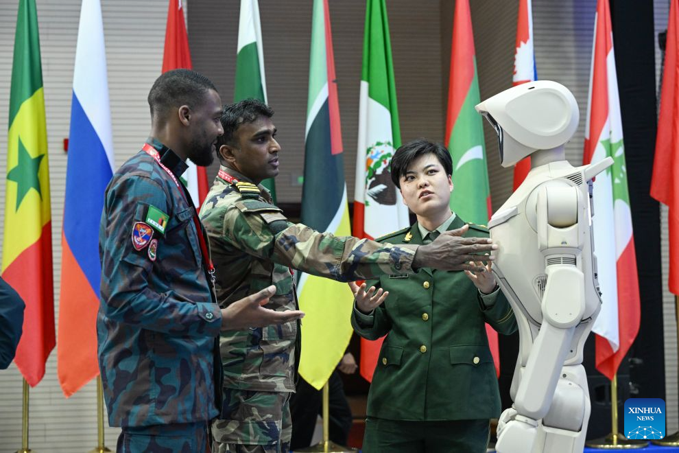 Peserta berinteraksi dengan sebuah robot pada Forum Antikeganasan Antarabangsa Great Wall-2026 di Beijing, ibu negara China, 14 Oktober 2026. (Foto oleh Yue Chang/Xinhua)