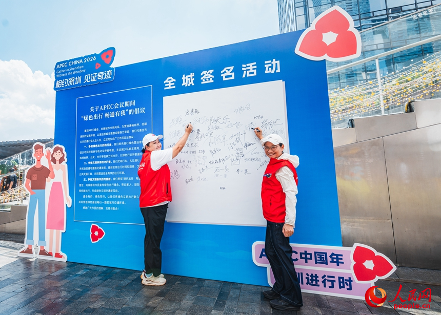 Penduduk Shenzhen menulis nama pada papan sebagai tanda menyokong mobiliti hijau. (People's Daily Online/Wang Xing)