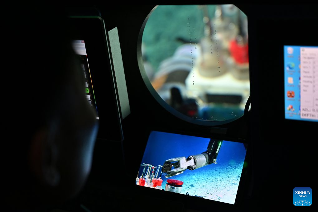 Pemandu, Tang Jialing mengendalikan sebuah lengan robotik untuk mengutip sampel batu dasar laut dari modul penyelam laut dalam berpenumpang Jiaolong pada 15 Oktober 2026. (Xinhua/Li Xin)