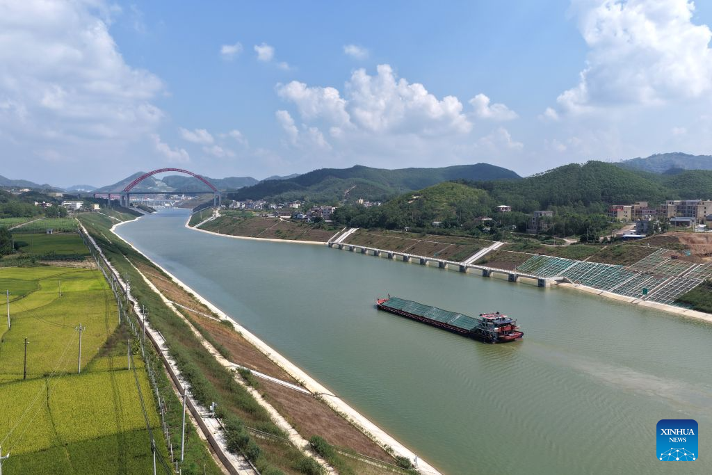 Foto dron bertarikh 21 Oktober 2026 menunjukkan sebuah kapal kargo berdekatan dengan jambatan Jiuzhou di Terusan Pinglu, wilayah autonomi Zhuang Guangxi, selatan China. (Xinhua/Zhou Hua)