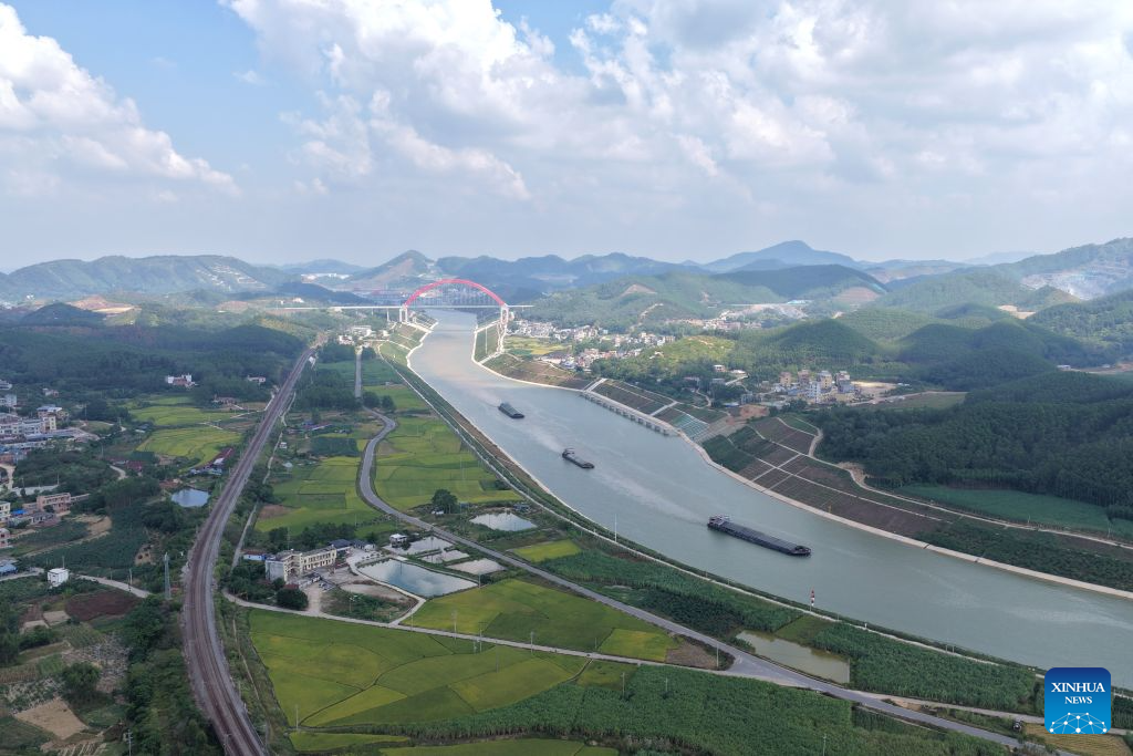 Foto dron bertarikh 21 Oktober 2026 menunjukkan sebuah kapal kargo berdekatan dengan jambatan Jiuzhou di Terusan Pinglu, wilayah autonomi Zhuang Guangxi, selatan China. (Xinhua/Zhou Hua)