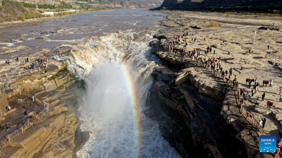 Foto dron yang diambil di kaunti Jixian, provinsi Shanxi, utara China pada 28 Oktober 2026 memaparkan fenomena pelangi di Air Terjun Hukou Sungai Kuning. (Foto oleh Lyu Guiming/Xinhua)