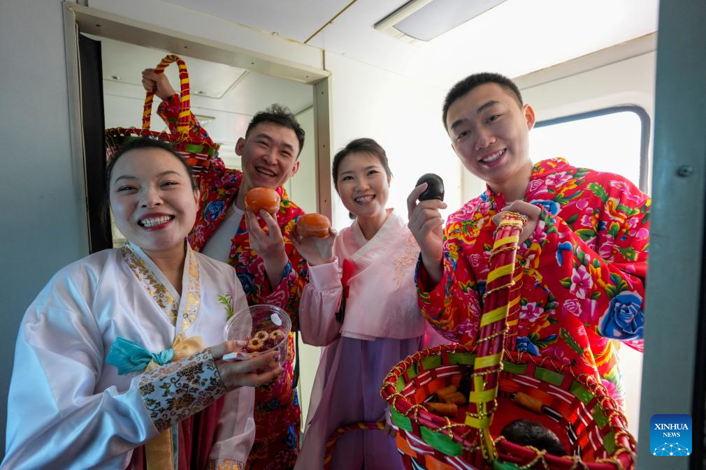 Pelayan berpakaian tradisional menunjukkan buah-buahan beku di sebuah “bazar dalam tren” di provinsi Heilongjiang, timur laut China, 4 Februari 2026. (Xinhua/Wang Song)