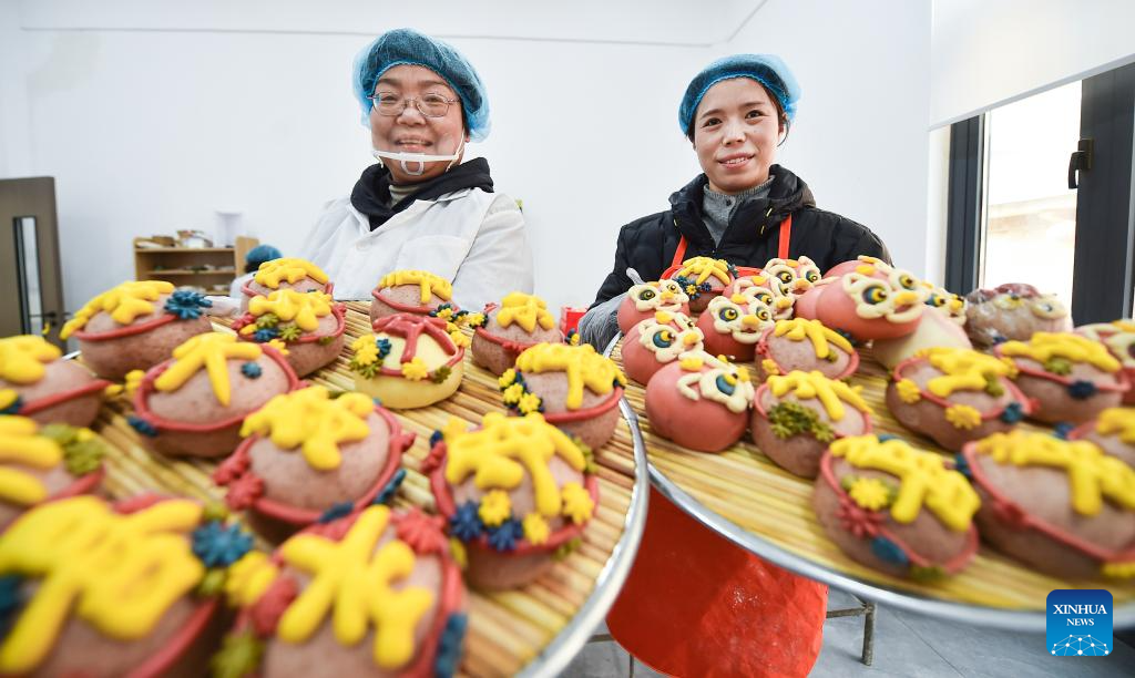 Pekerja mempamerkan ban kukus yang begitu artistik untuk dijual di bandar Luoyang, provinsi Henan, tengah China, 4 Februari 2026. (Huang Zhengwei/Xinhua)