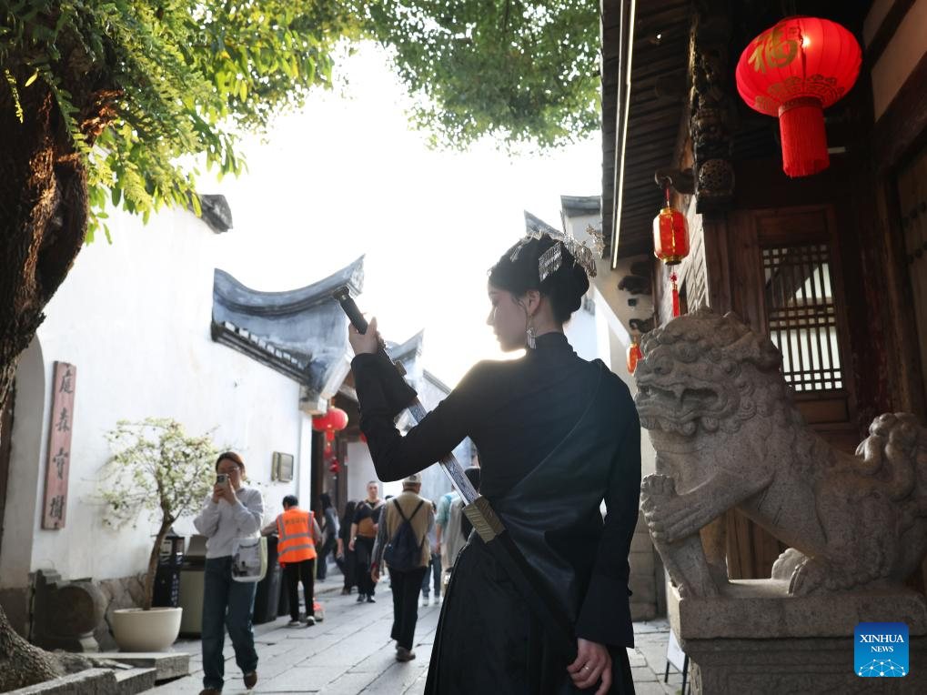 Seorang pelawat berpakaian tradisional bergambar di blok sejarah dan budaya “Tiga Jalan, Tujuh Lorong” di Fuzhou, provinsi Fujian, tenggara China, 21 Februari 2026. (Xinhua/Jiang Kehong)