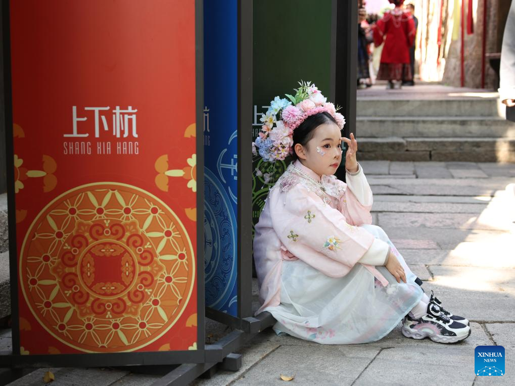 Seorang budak perempuan berpakaian tradisional berehat di Shangxiahang, Fuzhou, provinsi Fujian, tenggara China, 21 Februari 2026. (Xinhua/Jiang Kehong)