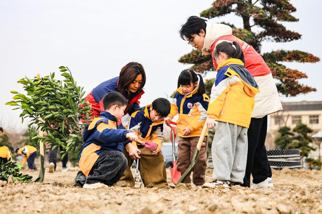 Kanak-kanak di sebuah tadika mengambil bahagian dalam acara menanam pokok bersama guru dan sukarelawan di Taixing, provinsi Jiangsu, timur China, 11 Mac 2026. (Foto oleh Gu Jihong/Xinhua)
