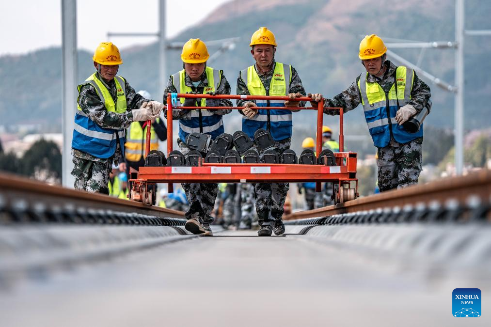Pekerja sedang menjalankan kerja-kerja pemasangan trek di tapak pembinaan kereta api laju Chongqing-Kunming di kaunti Songming, Kunming, provinsi Yunnan, barat daya China, 18 Mac 2026. (Xinhua/Hu Chao)