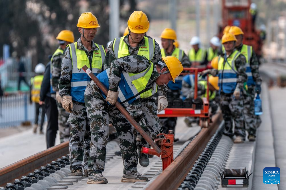 Pekerja sedang menjalankan kerja-kerja pemasangan trek di tapak pembinaan kereta api laju Chongqing-Kunming di kaunti Songming, Kunming, provinsi Yunnan, barat daya China, 18 Mac 2026. (Xinhua/Hu Chao)