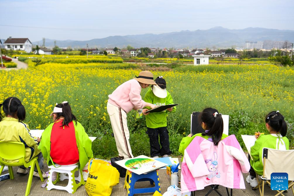 Pelajar belajar melukis di tempat pemandangan bunga sesawi di pekan Yanghe, bandar Hanzhong, provinsi Shaanxi, barat laut China, 28 Mac 2026. (Xinhua/Zou Jingyi)