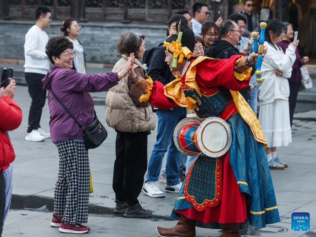 Peserta perarakan rakyat berinteraksi dengan pengunjung pada pesta rakyat di Wuzhen, bandar Tongxiang, provinsi Jiangsu, timur China, 1 April 2026. (Xinhua/Xu Yu)