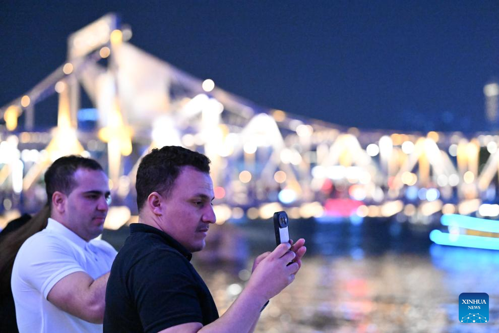 Pelancong dari Kanada menikmati panorama malam di sepanjang Sungai Haihe di Tianjin, utara China, 24 April 2026. (Xinhua/Sun Fanyue)