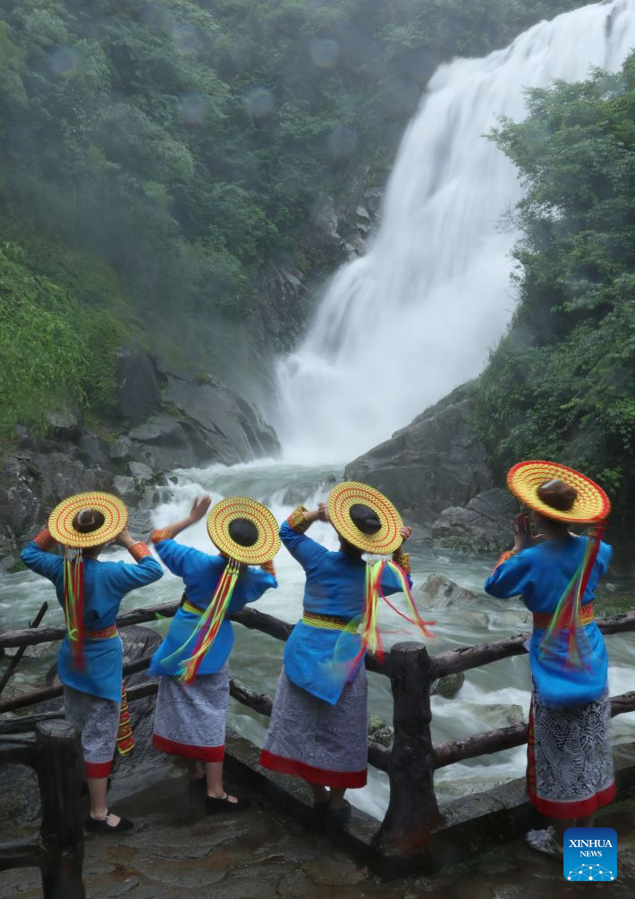 Wanita berkostum sulaman suji bilang Tiaohua mengunjungi air terjun di kaunti Longhui, Shaoyang, provinsi Hunan, tengah China, 24 Jun 2026. (Xinhua/Zhao Zhongzhi)